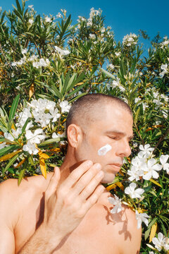 Man Applying Face Sunscreen Lotion to Skin Summer Outdoors