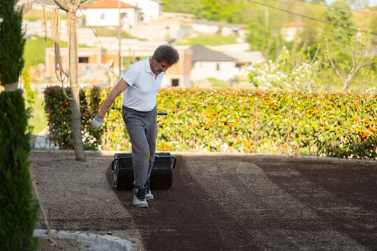 Man Walking While Leveling Soil