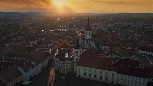 Aerial sunset 4k video of the Great Square in Sibiu, showing historic buildings, the Catholic and Lutheran Church, and the council tower, sunset landscape. Sibiu Transylvania landmarks. Romania video