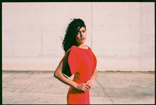 Woman posing in red dress outdoors