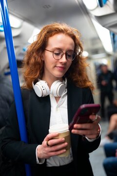Woman using smartphone inside subway train
