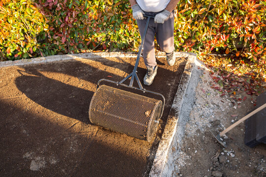 Top view of garden roller leveling soil bed