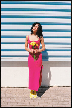 Woman in pink dress holding yellow flowers