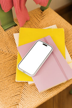 Colorful items on a chair and a mobile phone with a blank screen