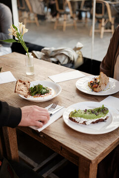 Anonymous waiter serving clients on a restaurant
