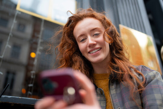 Woman sitting at cafe using phone
