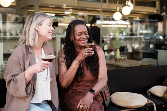 Two women enjoying cocktails on a pub