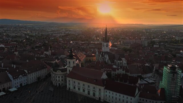 Aerial sunset 4k video of the Great Square in Sibiu, showing historic buildings, the Catholic and Lutheran Church, and the council tower, sunset landscape. Sibiu Transylvania landmarks. Romania video