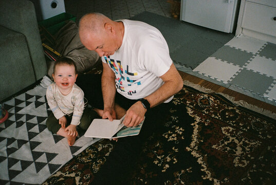 Grandfather reading book to granddaughter
