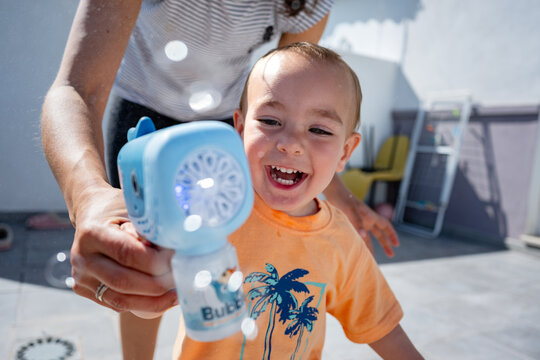 Toddler playing with bubble machine