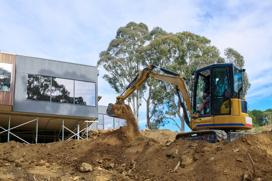 Construction Site With Excavator Moving Dirt Near Home Build