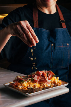 Gourmet toast with prosciutto, scrambled egg and seeds