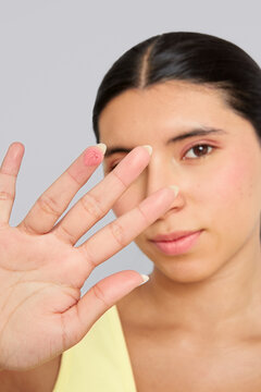Woman holding makeup sample on finger for beauty care