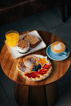 Cozy cafe brunch with pancakes, fruit and latte art