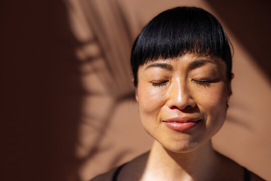 Serene Woman Portrait Bathed in Warm Sunlight and Shadow
