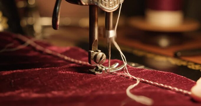 sewing machine stitching red fabric.