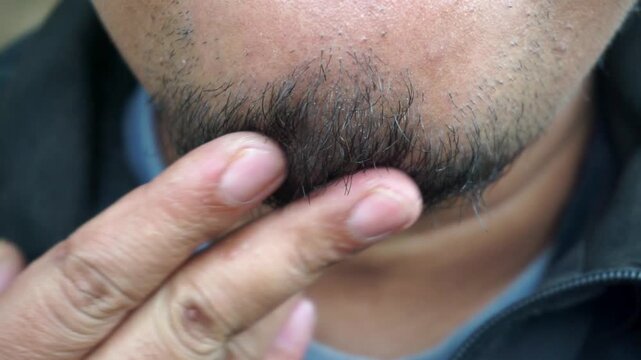 Close-up shot of an adult man's unshaven beard and chin hair.