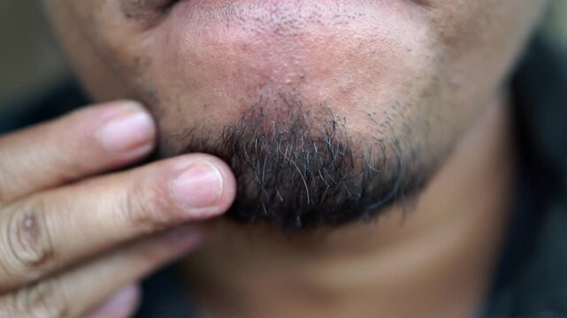 Close-up shot of an adult man's unshaven beard and chin hair.
