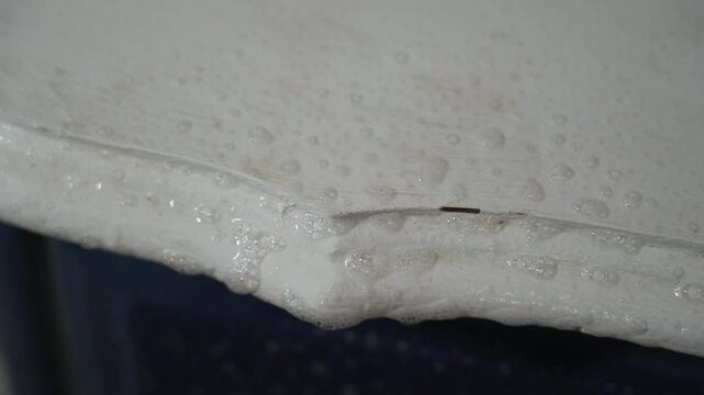 Macro closeup of a man's hand scrubbing and sanitizing a white surface with a white towel. Household tasks. Home chores. Spring cleaning.