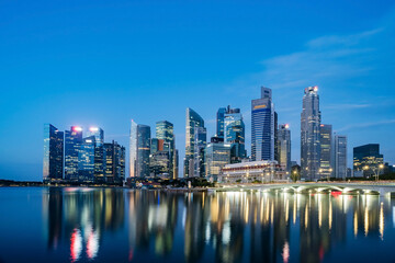 Naklejka premium Singapore skyline at Marina Bay during blue hour, city lights turning on