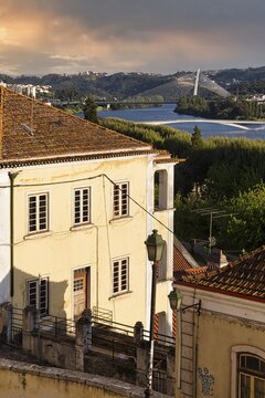 View over rooftops on river Mondego with Ponte Rainha Santa Isabel and Ponte Pedro e In&ecirc;s, old town of Coimbra, Portugal