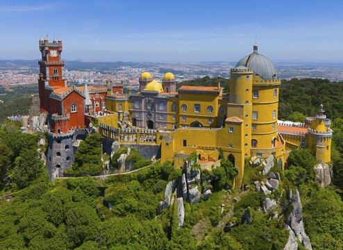 Magnificent castle with colourful towers and buildings in a green, hilly landscape under a blue sky, aerial view, Pal&aacute;cio Nacional da Pena, National Palace Pena, Sintra, Lisbon, World Heritage Site, UNESCO, Portugal