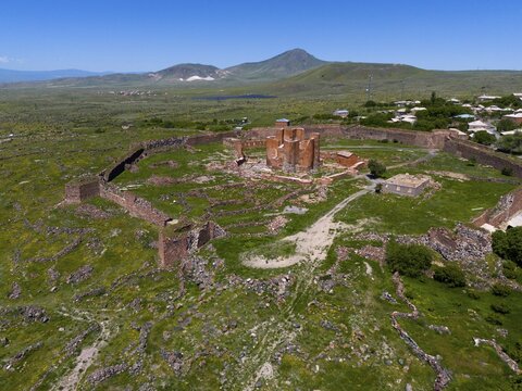 Expansive view of a historic fortress with surrounding stone walls in a green mountain landscape, Dashtadem Fortress, Qagheni Fortress, Dashtadem village, Aragatsotn Province, Armenia