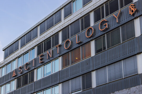Amsterdam, Netherlands: Exterior facade of a modern multi-story office building featuring the large metallic Scientology sign and symbol.