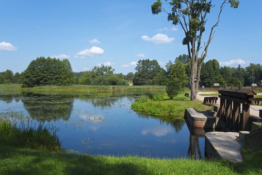 Idyllic pond with green trees and blue sky, a bridge in the foreground, peaceful landscape, landscape near the Tartak lock, Augustow Canal, Suwałki, Podlaskie, Podlaskie, Poland
