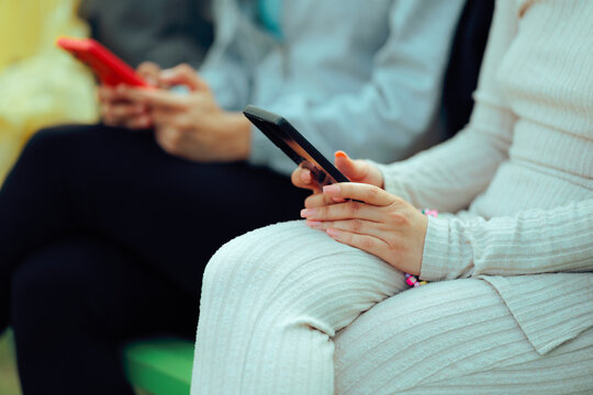 Friends Ignoring Each Other Texting on Smartphones 
Unrecognizable women using mobile phones instead of talking