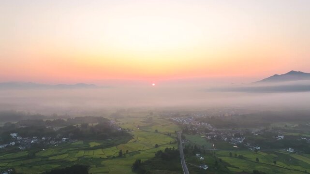 Aerial Sunrise Over Misty Rural Village and Farmland Valley