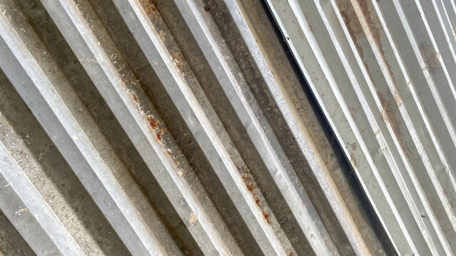 Abstract pattern texture background. Galvanized iron sheet or corrugated zinc sheet, some parts of which are rusty. Close up view of galvanized iron sheet roof or corrugated zinc sheet, geometric line