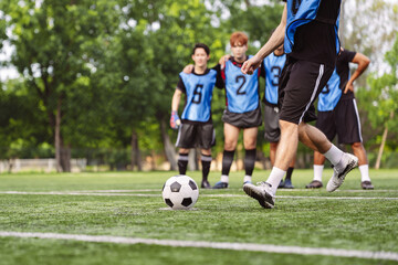 Fototapeta premium Soccer player kicking a ball on an artificial grass field during training. Action, teamwork, active lifestyle, and sports competition concept.