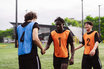 Soccer players shaking hands on the field to show sportsmanship and respect after a match. Teamwork and fair play concept in sports. © Kiattisak
