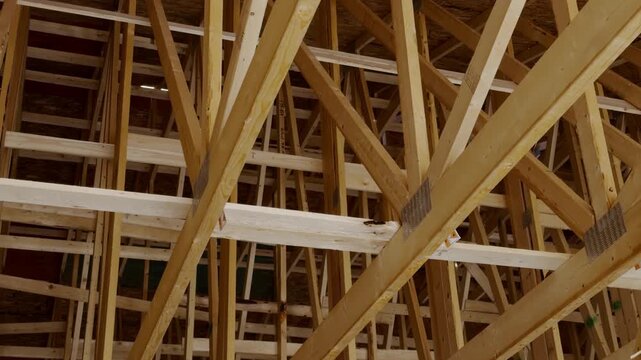 Wood framing a new residential house under construction with unfinished walls and structural support beams