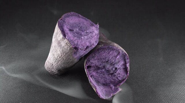 Cut Purple Sweet Potato Surrounded By Smoke On Black Background