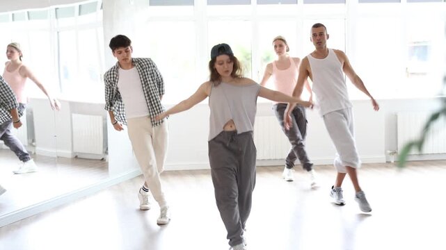 Dance group in casual clothes training to dance hip-hop and breakdance together in a dance center. High quality 4k footage