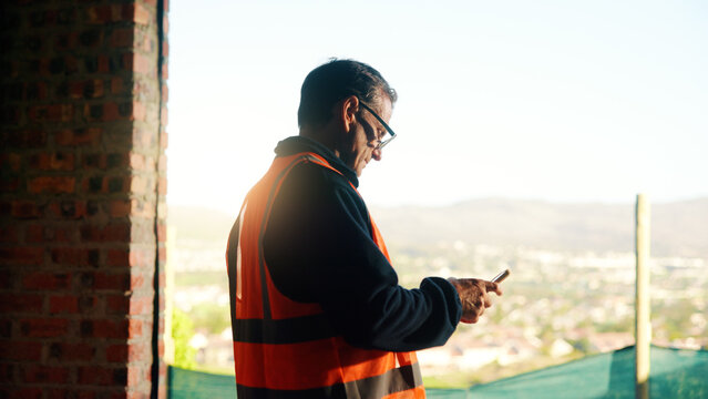 Manager, construction and man with phone on site for timesheet review, safety log or texting. Foreman, mature person and mobile app in building for project communication, compliance checklist or chat