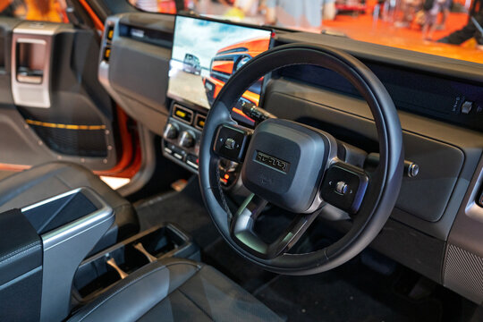 Penang, Malaysia - May 2, 2026: An interior view of the Chery iCAR V23 electric SUV, highlighting its rugged black leather steering wheel, large floating center touchscreen at a showroom.