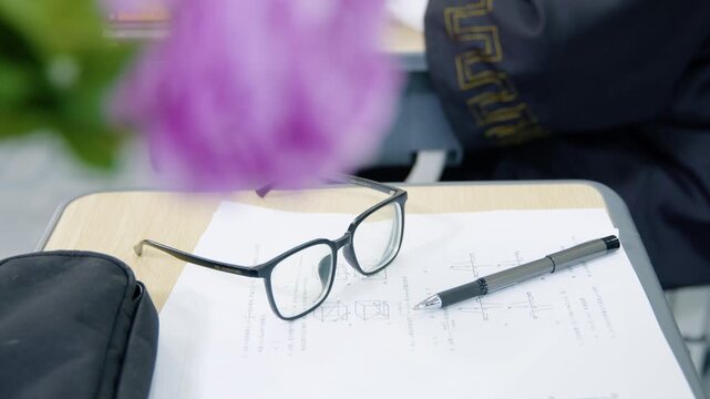 Eyeglasses and Pen on Math Worksheet at Classroom Desk