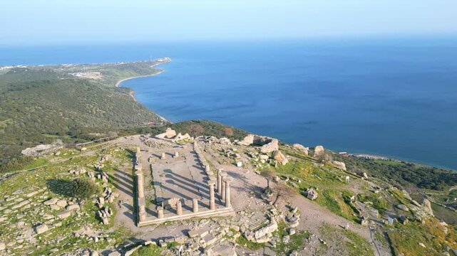 Aerial view of the ancient Temple of Athena ruins on the acropolis of Assos (Behramkale) over the Aegean Sea in Canakkale, Turkey. 4K resolution stock footage. High quality 4k footage