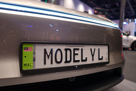 Penang, Malaysia - May 02, 2026: Front view bumper of a grey Tesla with Malaysian electric vehicle license plate "JPJ e-plate' with a green side strip, a small Malaysian Flag and Model Y L lettering.