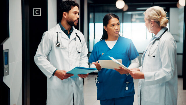 Meeting, hallway and doctors with paperwork in hospital for planning, surgery schedule and diagnosis. Healthcare, clinic and people with notes for consulting, treatment and medical service with team