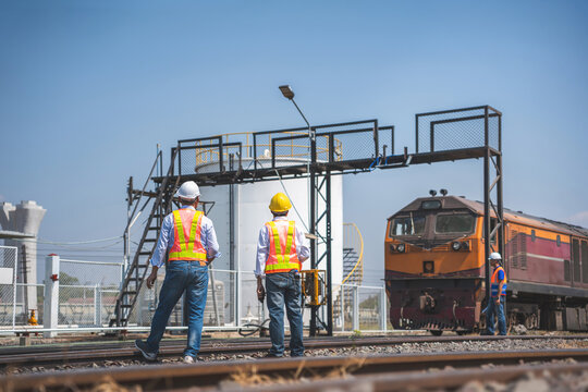 Railway construction team coordinating transport infrastructure project, Professional railway engineer and technical team checking freight train and inspecting train tracks at rail terminal operations