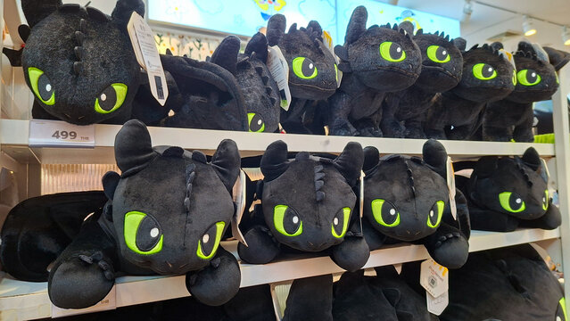 Cute Toothless Night Fury black dragon plush toys with green eyes displayed on shelves in a toy store retail shop on May 18, 2026 in Bangkok, Thailand.