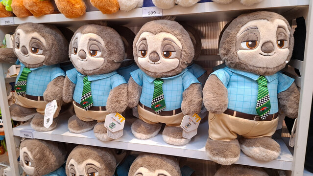 Cute Flash the sloth plush dolls from Zootopia movie wearing blue shirts and green ties displayed on shelves in a toy store on May 18, 2026 in Bangkok, Thailand.