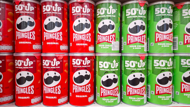 Pringles potato chips cans in red original and green sour cream flavors stacked on a supermarket retail shelf on May 14, 2026 in Bangkok, Thailand.