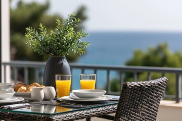 Fototapeta premium Breakfast on terrace with ocean view, morning juice and fresh bread on table