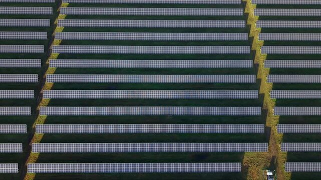 90 degree overhead aerial drone shot of intricate photovoltaic solar panel arrays in winter sunlight