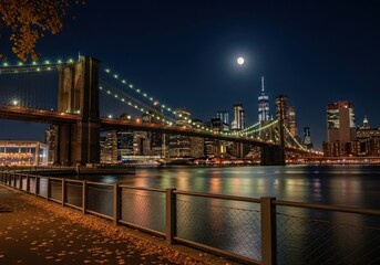 Fototapeta premium Brooklyn bridge and new york city skyline at night with a bright full moon reflecting in the east river water